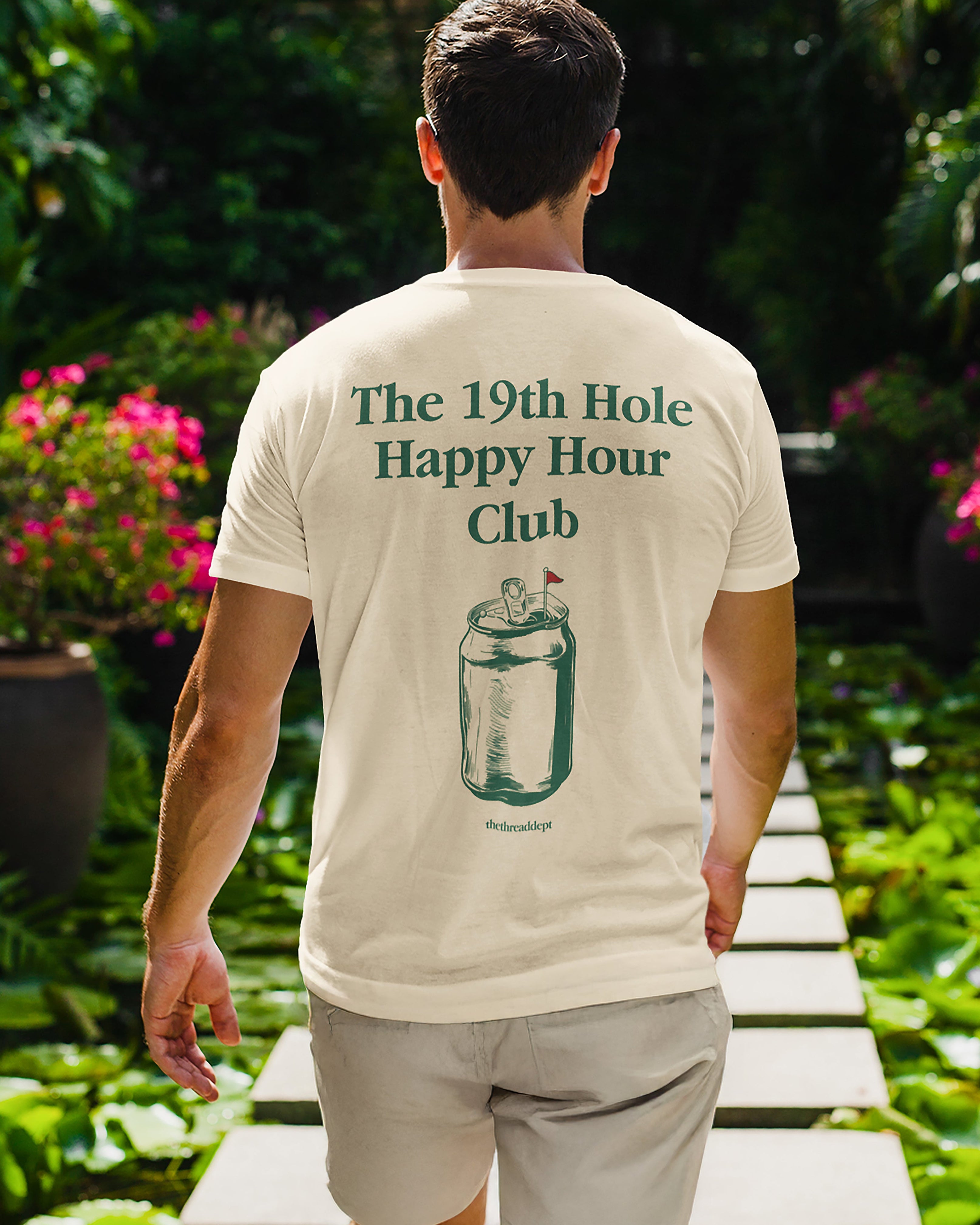 Man wearing a 'The 19th Hole Happy Hour Club' t-shirt in a garden setting