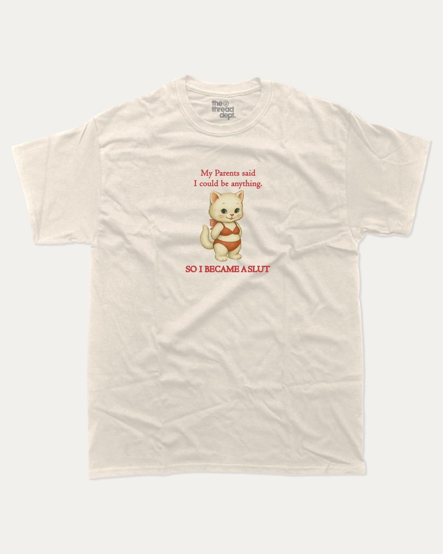 Beige t-shirt with a cartoon cat i became a slut graphic and text on a white background