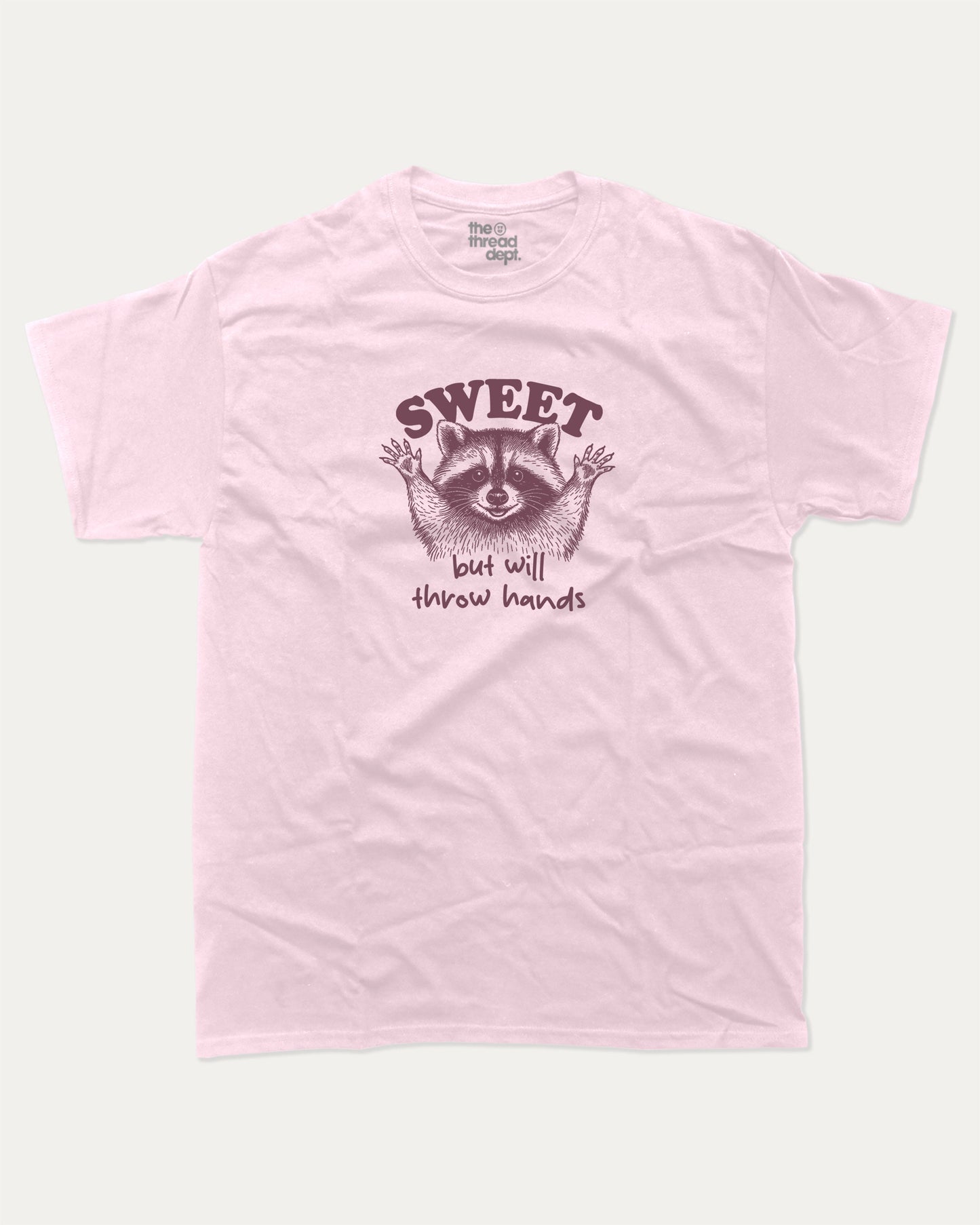 Sweet But Will Throw Hands Raccoon graphic t-shirt, perfect for gifts. Funny raccoon tee, trending meme shirt, unique gift idea. Pink.