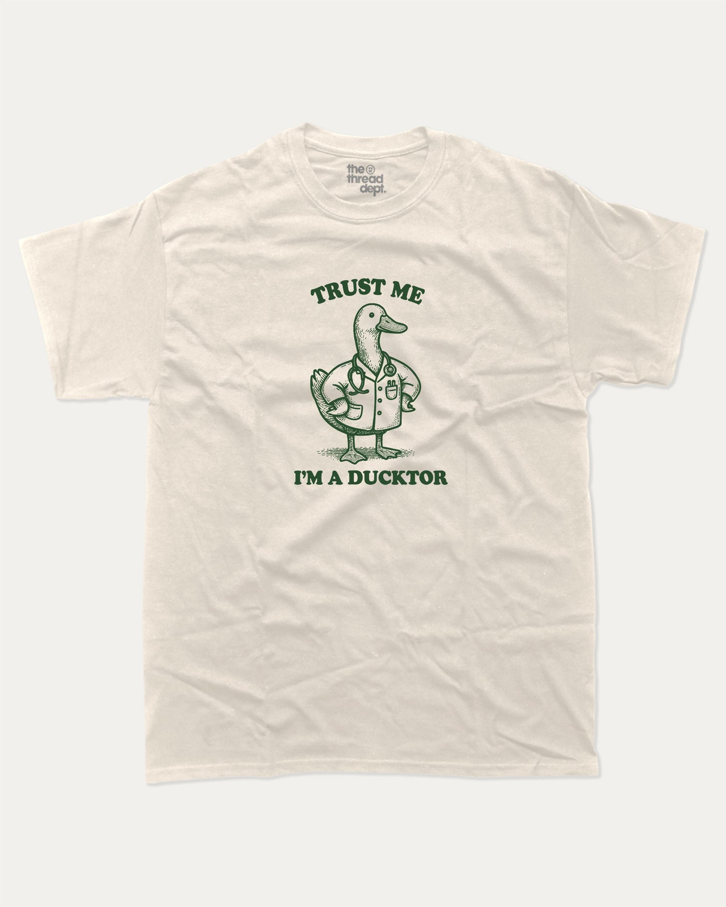 Trust Me I'm A Ducktor graphic t-shirt, perfect for gifts. Funny duck graphic tee, trending meme shirt, unique gift idea. Cream.