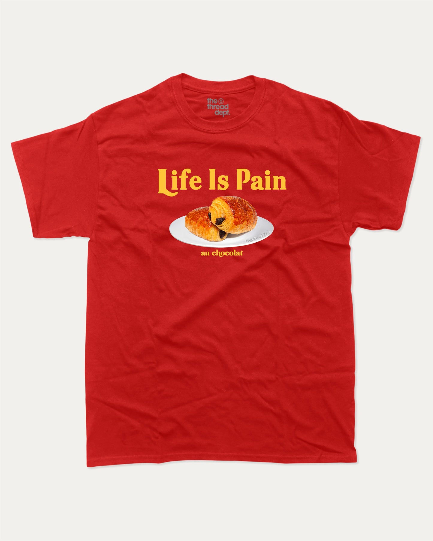 Life Is Pain Au Chocolat graphic t-shirt, perfect for adults. Funny bread tee, trending meme shirt, unique gift idea. Red.