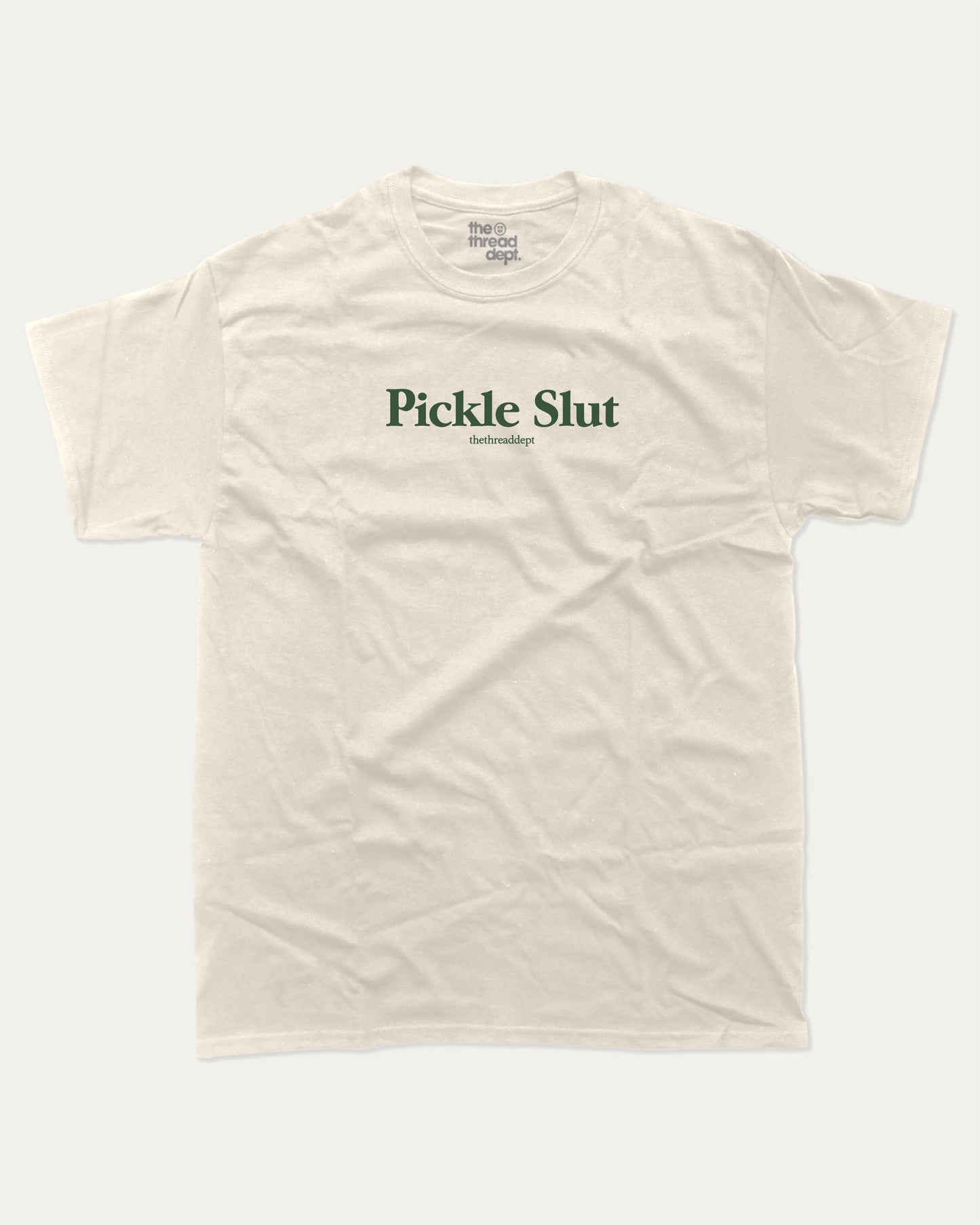 Pickle Slut graphic tee with bold and humorous print, funny and trendy graphic. Perfect Gift for Food Lover, Pickle Graphic T shirt, Craving Graphic T shirt, Snack Graphic T shirt, Perfect for adults and gift-giving. Cream shirt.