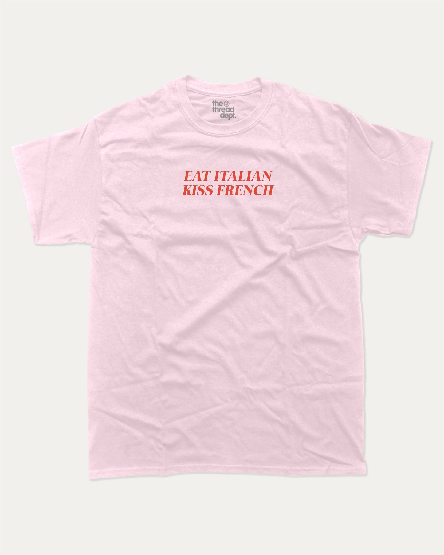 Eat Italian Kiss French graphic tee with bold and humorous print, funny and trendy graphic. Perfect for adults and gift-giving. Pink shirt.