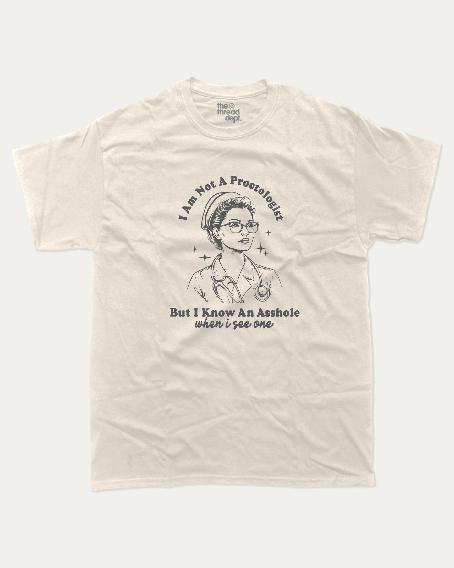 Beige t-shirt with I am not a Proctologist but I know asshole when I see one graphic and text on a white background