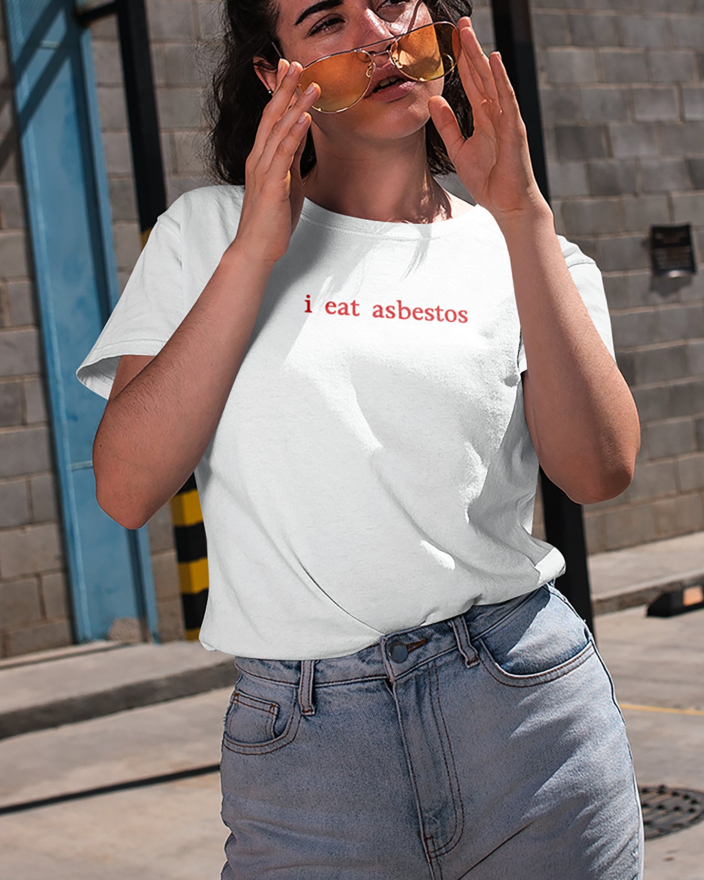 Person wearing a I Eat Asbestos t-shirt with 'i eat asbestos' text on a street.