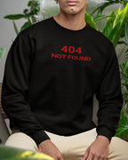 Person wearing a black sweatshirt with '404 Not Found' in red text, sitting in a room with plants.