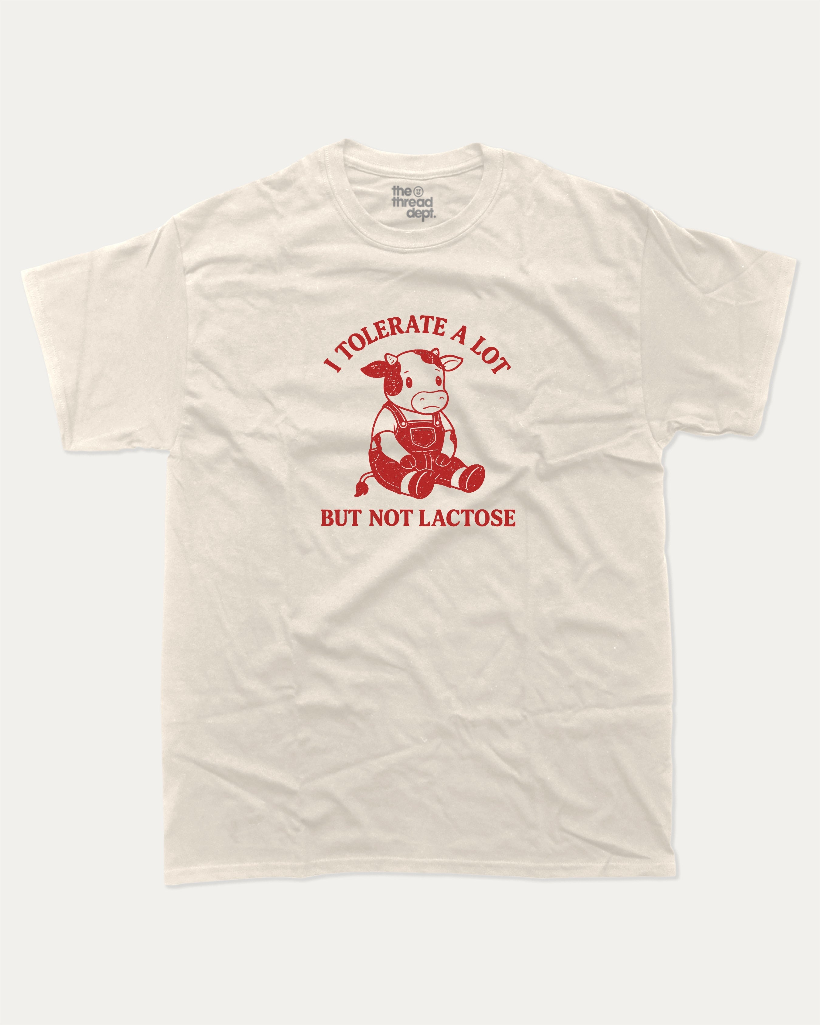 I Tolerate A Lot But Not Lactose graphic tee with cute cow print, funny and trendy graphic. Perfect for adults and gift-giving. Cream shirt.
