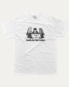 Paws On the Table graphic tee with bold and humorous print, funny and trendy graphic. Perfect for adults and gift-giving. White shirt.