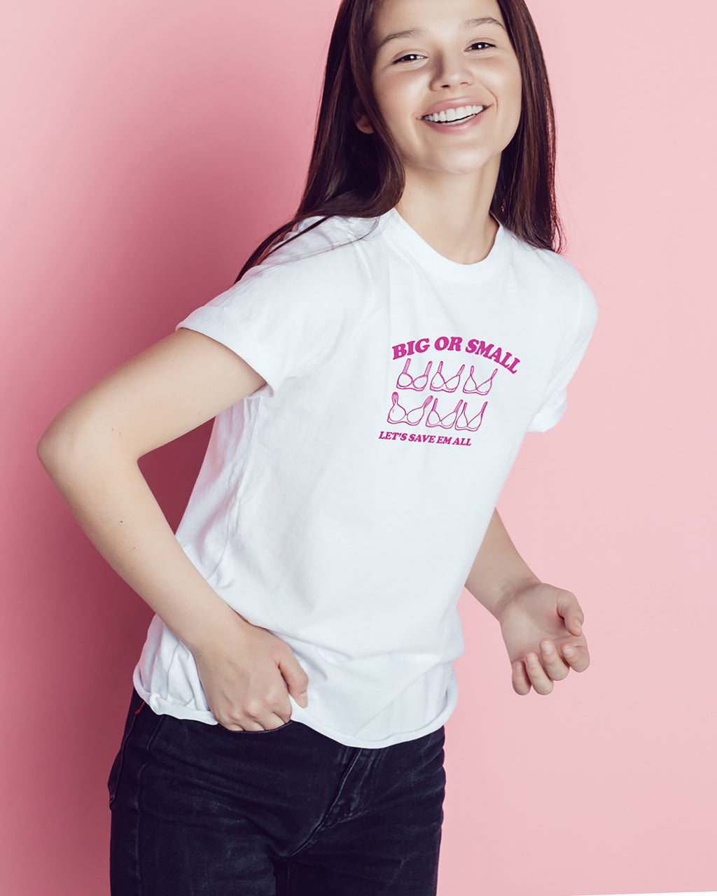 Young girl wearing a white t-shirt with 'Big or Small' pink text on a pink background