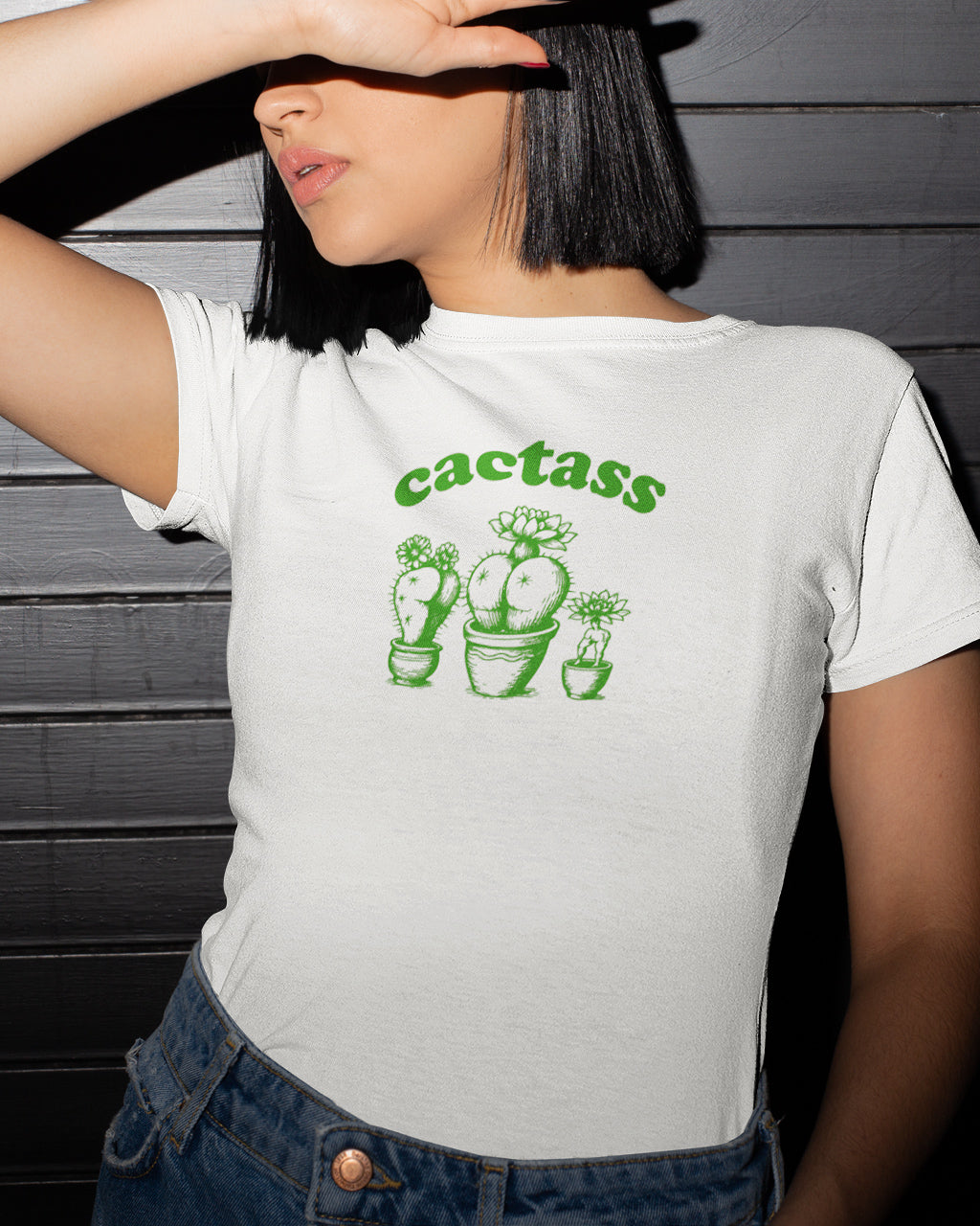 Person wearing a white t-shirt with green cactass funny graphics.