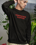 Person wearing a black sweatshirt with 'CERTIFIED YAPPER' text in red, standing in a blurred indoor setting with plants.