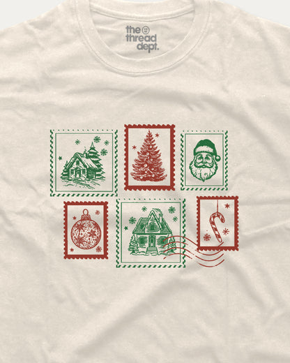 White t-shirt with Christmas-themed stamps design on a white background