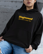Person wearing a black hoodie with "diagnosed but mom said no" text against a gray wall.