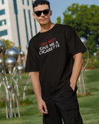 Person wearing a black t-shirt with "Do not give a cigarette" text in an outdoor setting