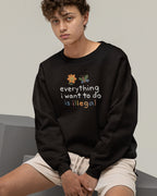 Person wearing a black sweatshirt with colorful text and graphics on a neutral background
