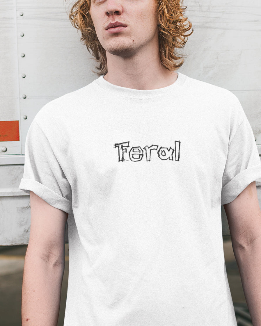 Person wearing a white t-shirt with 'Feral' printed on it against a plain background