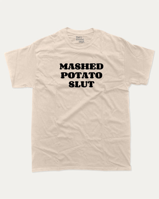Mashed Potato Slut graphic tee with bold and humorous print, retro mashed potato graphic. Perfect for adults and gift-giving. Sand shirt.