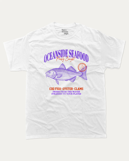 Oceanside Seafood graphic tee with bold and humorous print, Food Graphic Tee, Seafood Lover, Retro Inspired Graphic T shirt, Cute Retro Vintage Graphic T shirt, funny and trendy graphic. Perfect for adults and gift-giving. White shirt.