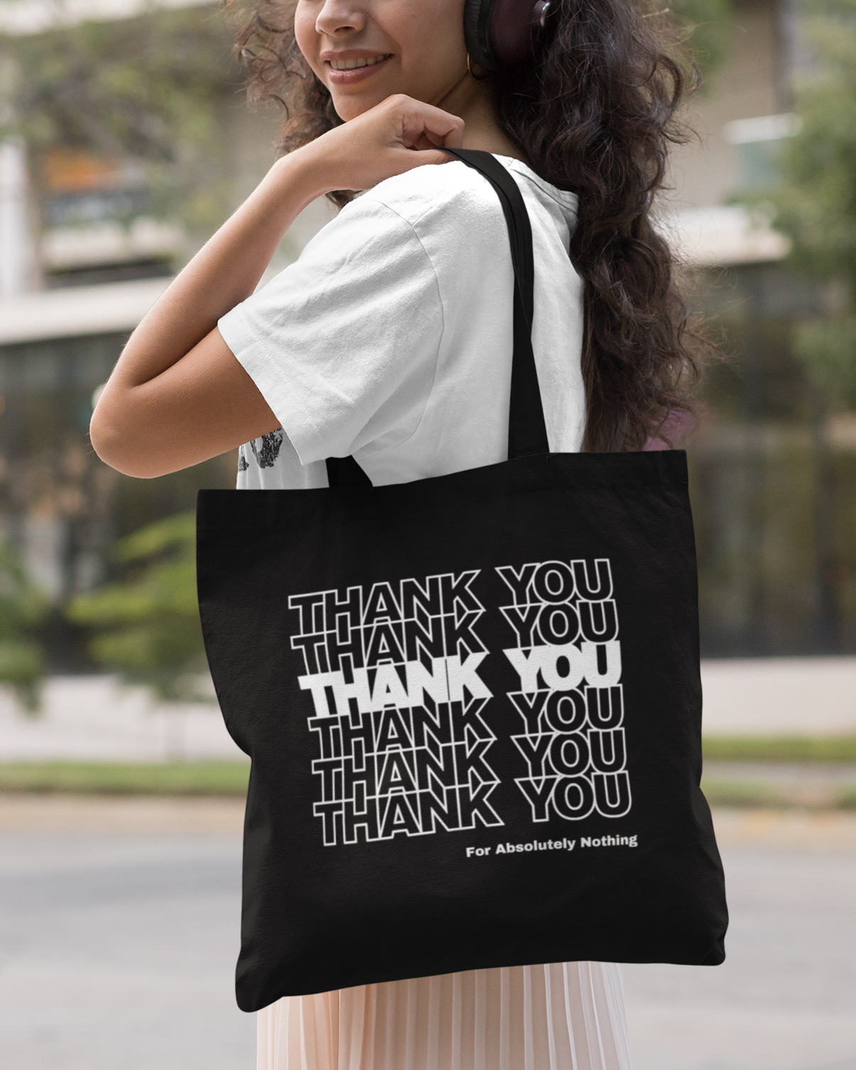 Person holding a black tote bag with 'THANK YOU' text in white.