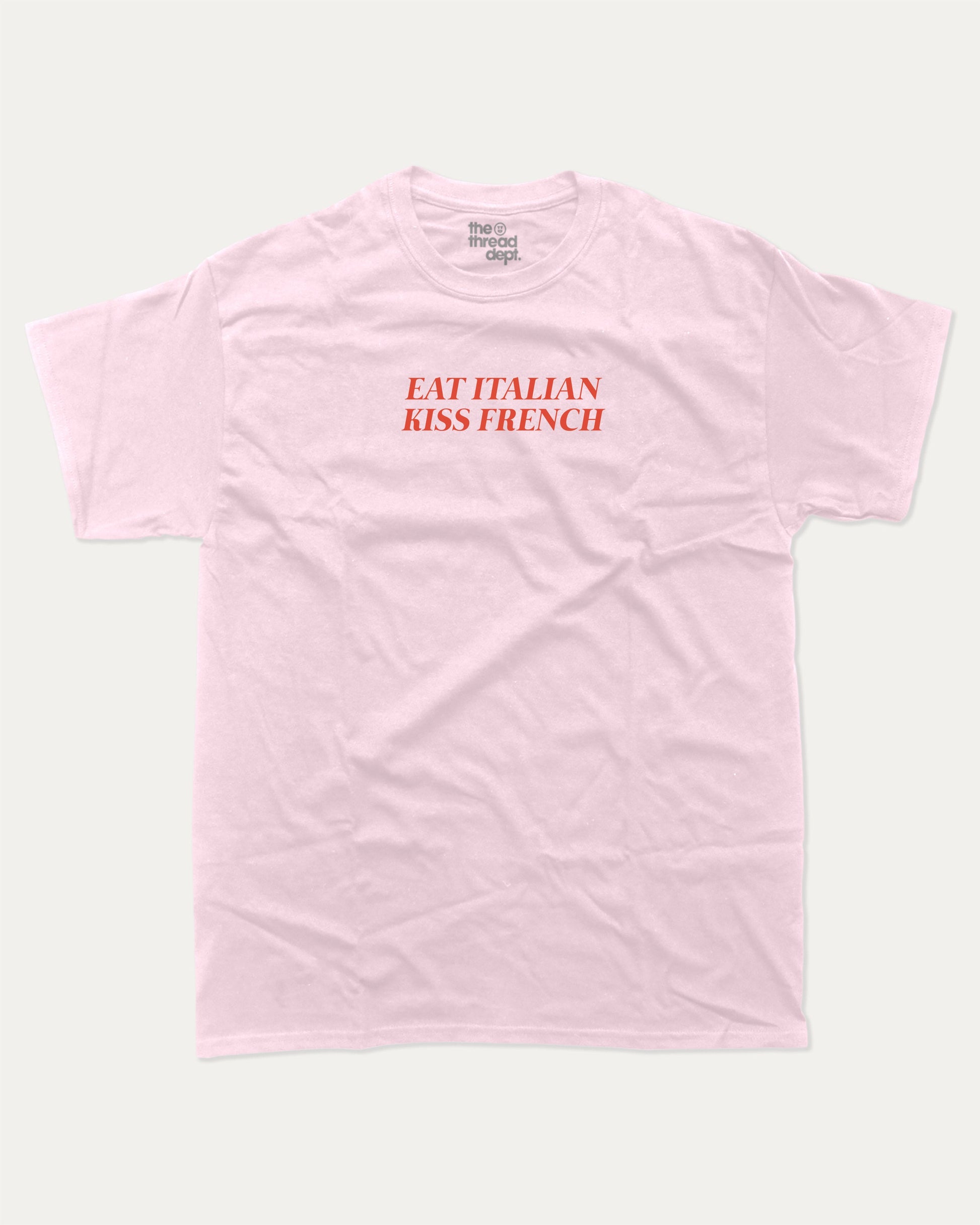 Eat Italian Kiss French graphic tee with bold and humorous print, funny and trendy graphic. Perfect for adults and gift-giving. Pink shirt.