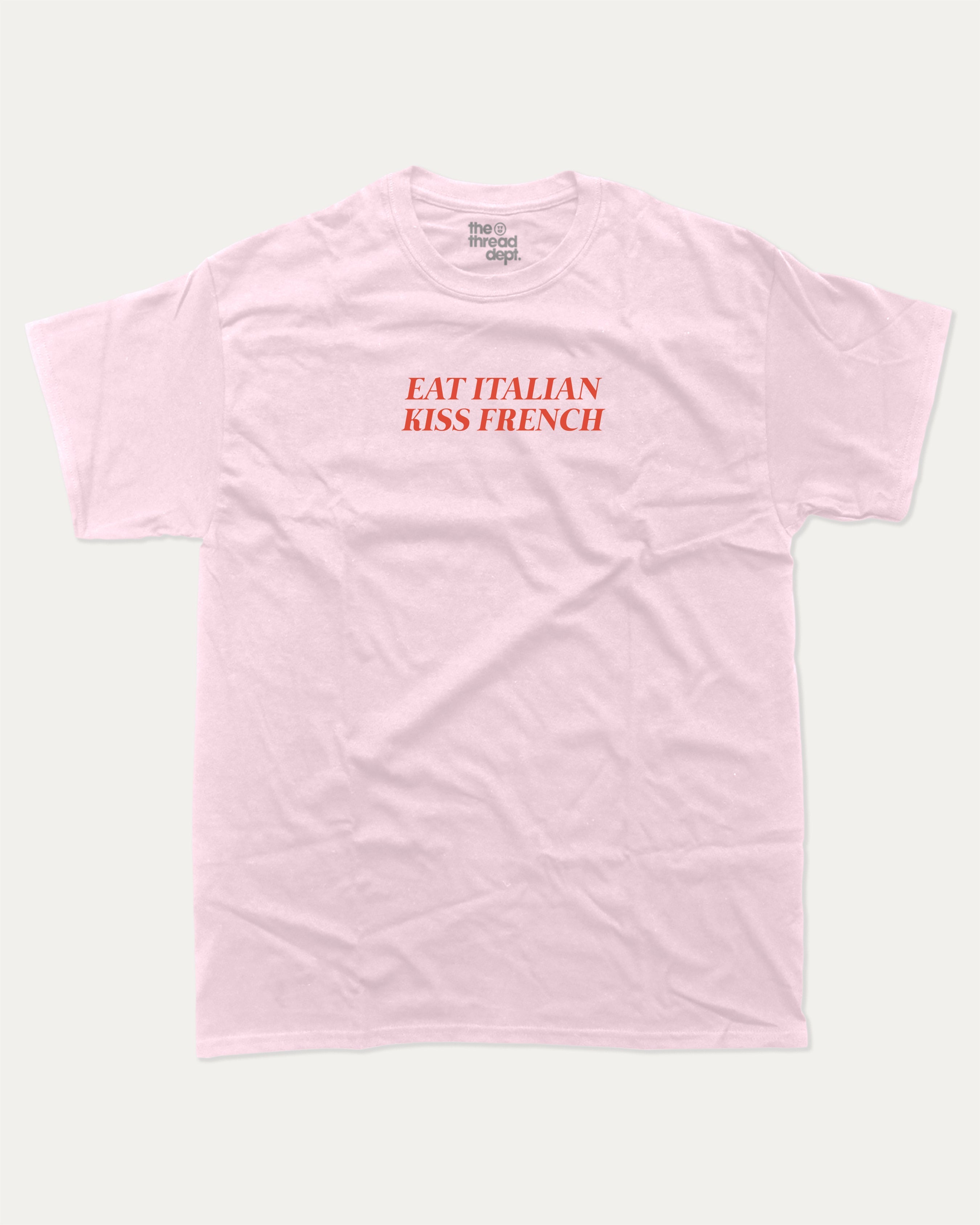Eat Italian Kiss French graphic tee with bold and humorous print, funny and trendy graphic. Perfect for adults and gift-giving. Pink shirt.