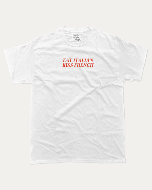 Eat Italian Kiss French graphic tee with bold and humorous print, funny and trendy graphic. Perfect for adults and gift-giving. White shirt.