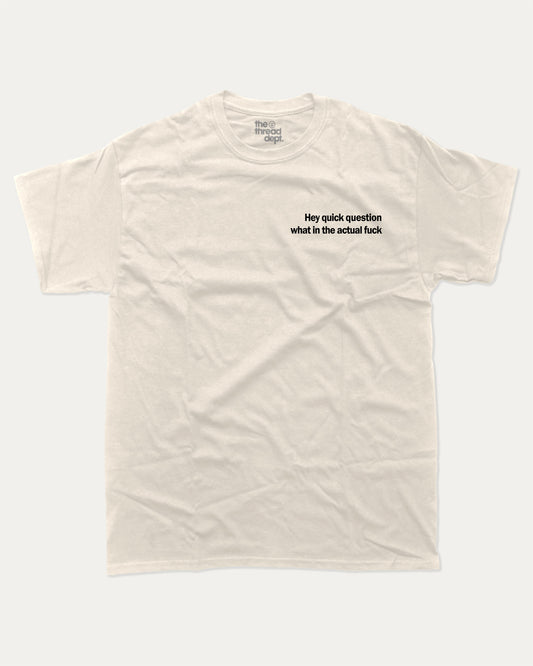 Hey Quick Question What In The Actual Fuck graphic tee with bold and humorous print, funny and trendy graphic. Perfect for adults and gift-giving. Cream shirt.