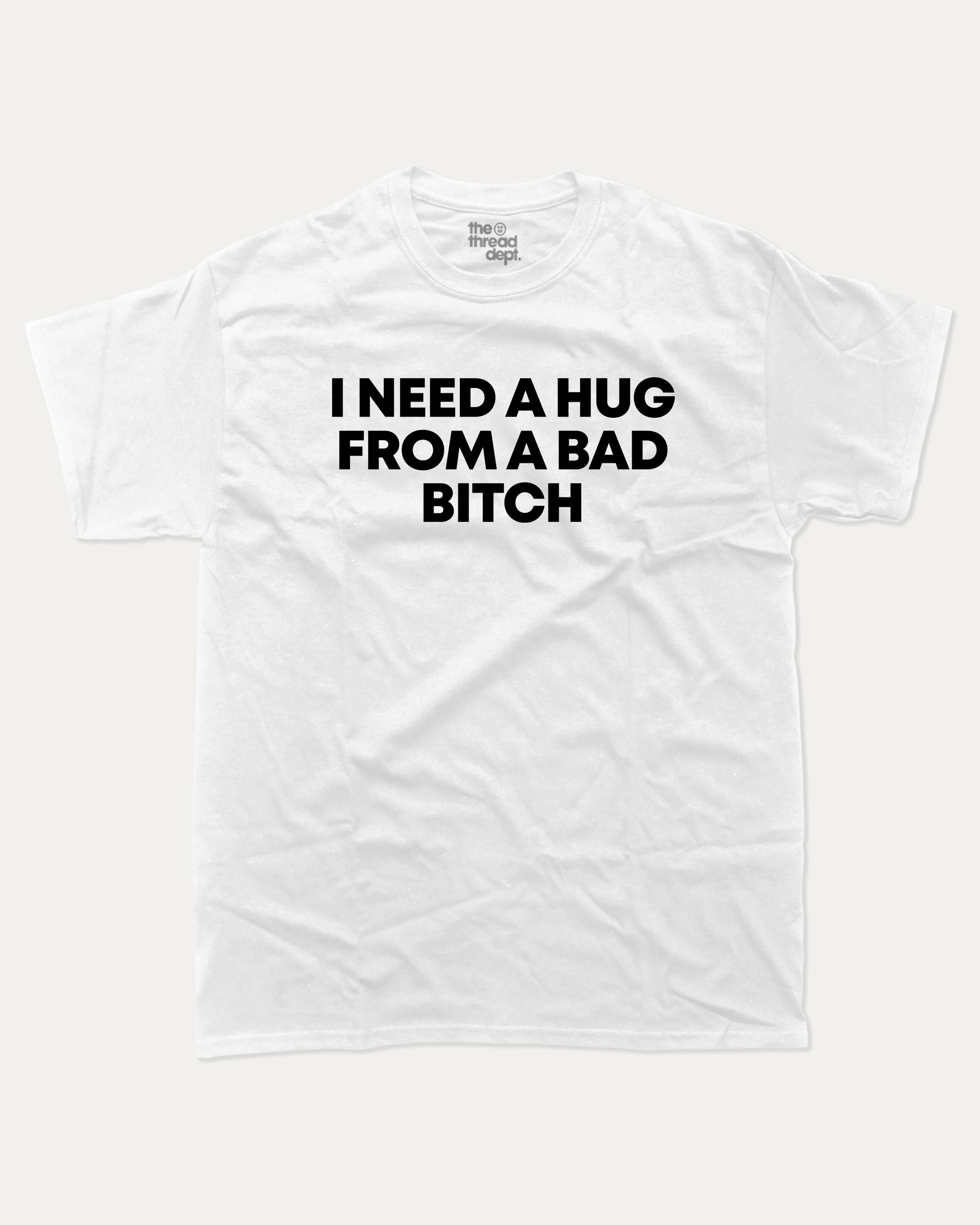 I need a hug from a bad bitch graphic tee with bold and humorous print, Funny meme graphic tee, funny and trendy graphic. Perfect for adults and gift-giving. White shirt.