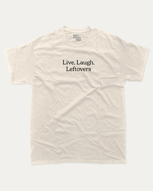 Live Laugh Leftovers graphic tee with bold and humorous saying print, funny and trendy graphic. Perfect for adults and gift-giving. Cream shirt.