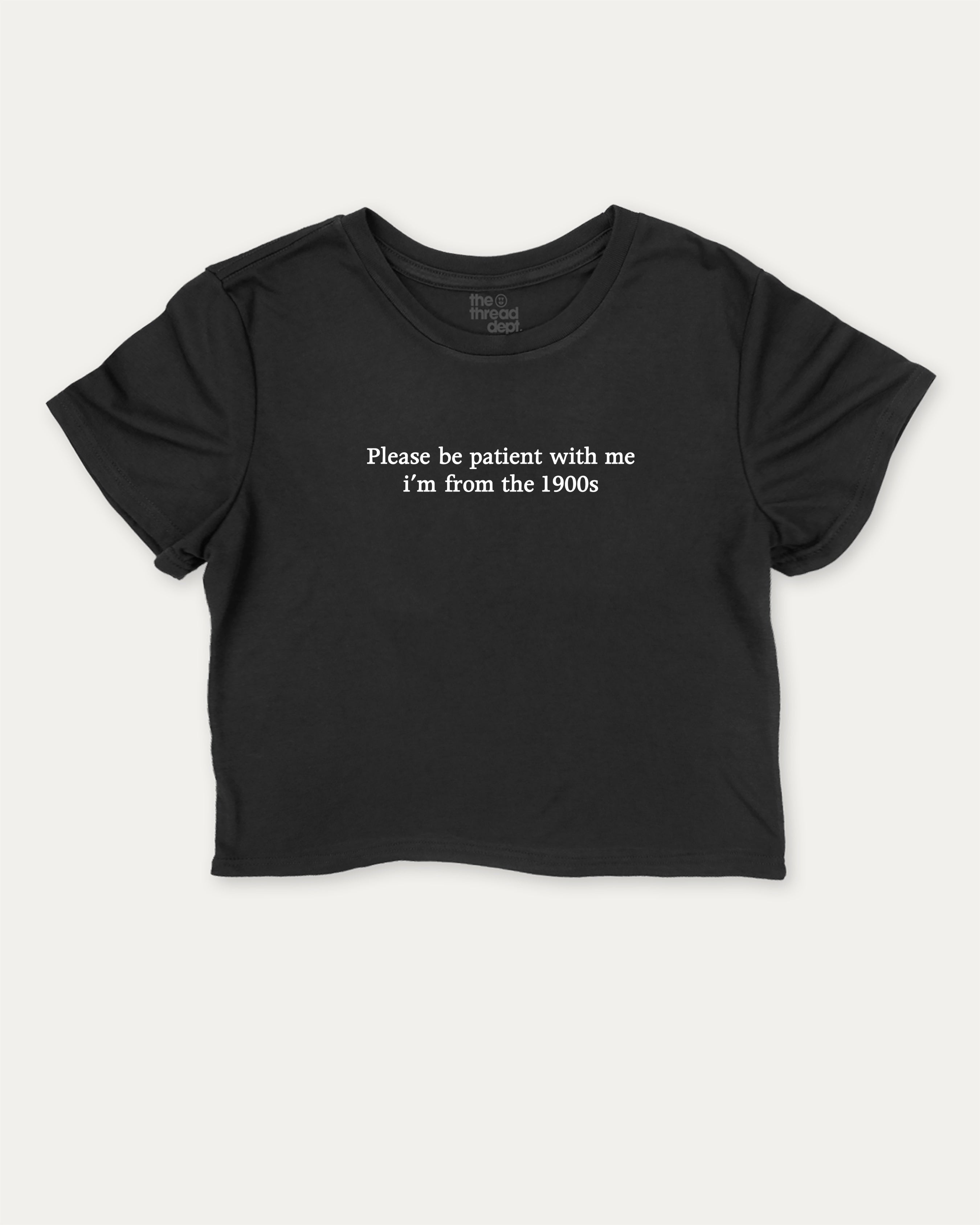Please Be Patient With Me I'm From The 1900s graphic crop tee with funny and retro slogan print, perfect for women_ casual looks or layering. Black crop t-shirt.