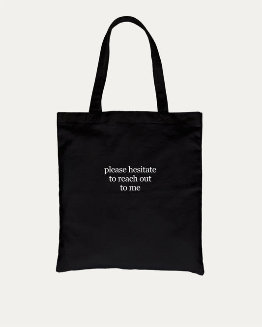 Please Hesitate To Reach Out To Me cotton canvas tote bag with humorous graphic, perfect for everyday carry. A must-have aesthetic accessory, great for shopping, school, or casual days. Special gifts for friends. Black bag