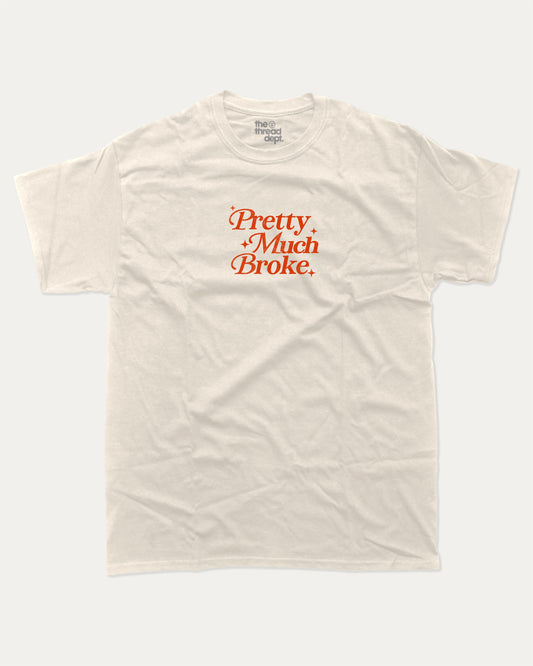 Pretty Much Broke graphic tee with bold and humorous print, funny and trendy graphic. Perfect for adults and gift-giving. Cream shirt.