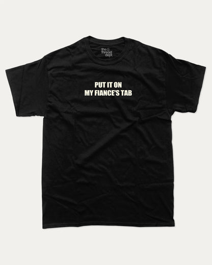 Put It On My Fiance's Tab graphic tee with bold and humorous print, funny and trendy graphic. Perfect for adults and gift-giving. Black shirt.