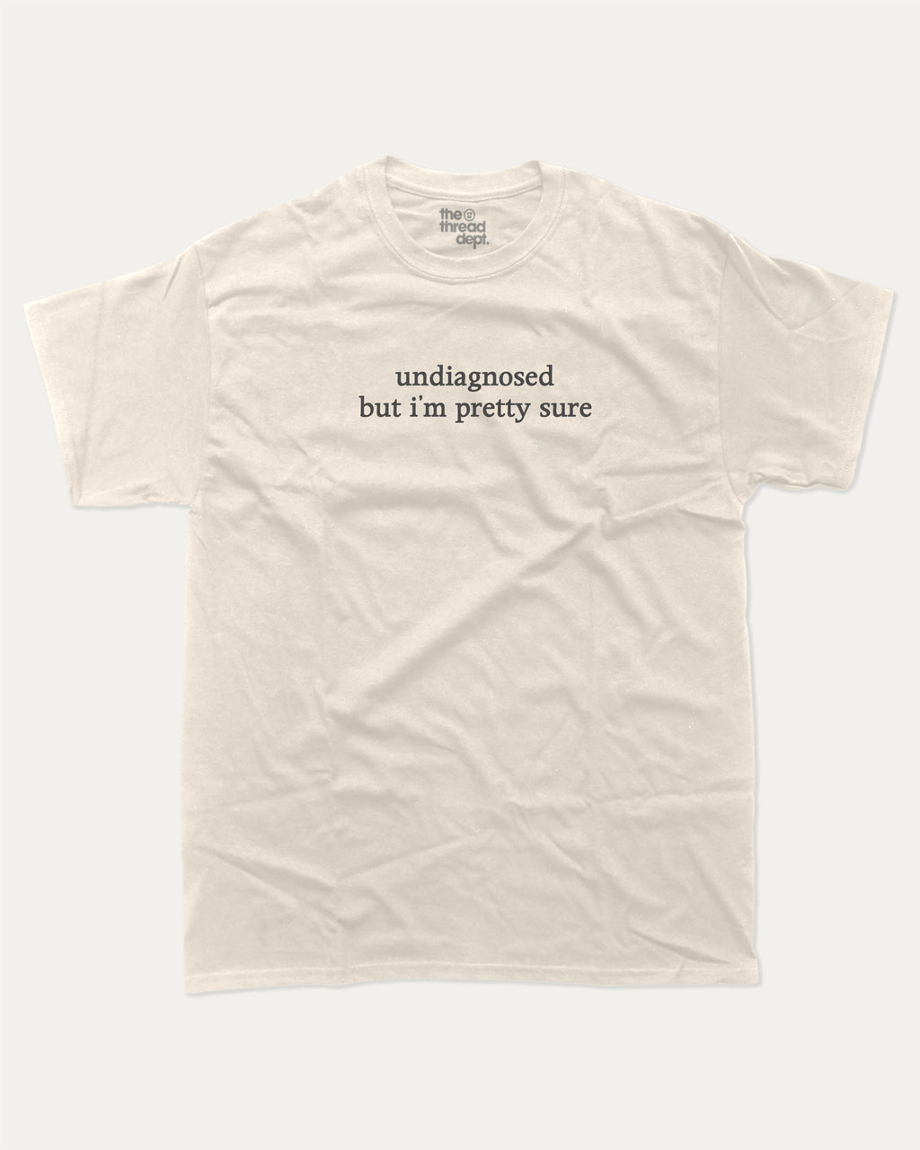Undiagnosed But I'm Pretty Sure graphic t-shirt, perfect for adults. Funny mental health tee, trending meme shirt, unique gift idea. Cream.