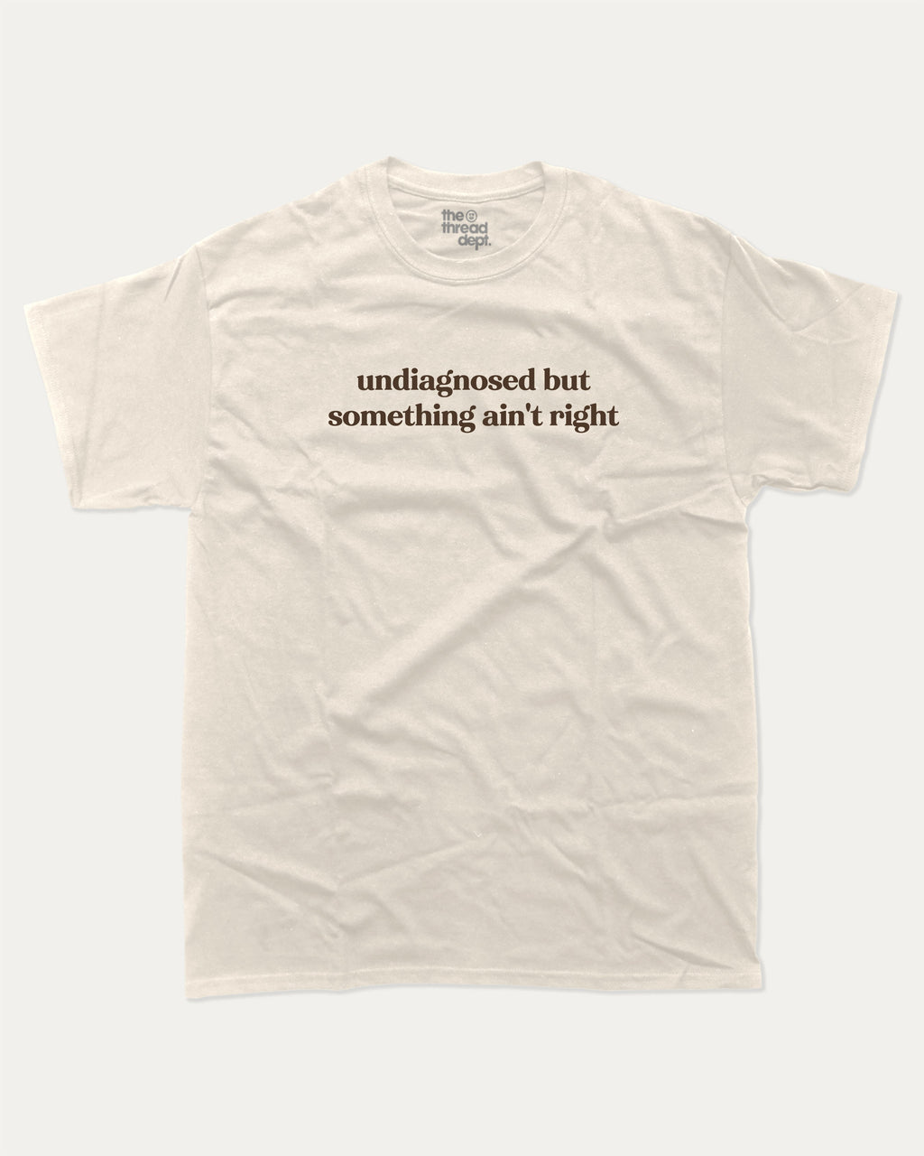 Undiagnosed But Something Ain't Right graphic t-shirt, perfect for adults. A must-have funny tee, trending meme shirt, unique gift idea. Cream.
