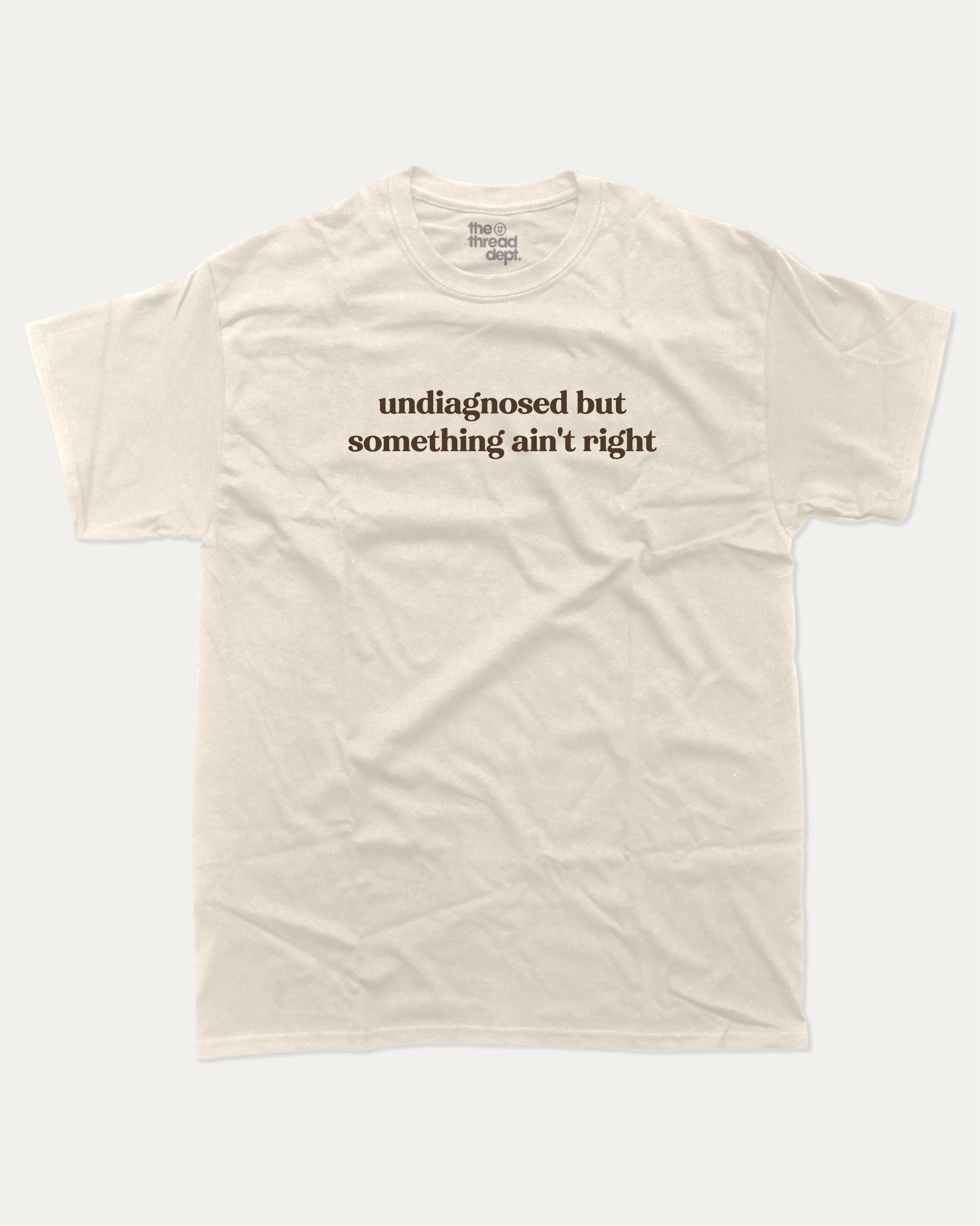 Undiagnosed But Something Ain't Right graphic t-shirt, perfect for adults. A must-have funny tee, trending meme shirt, unique gift idea. Cream.