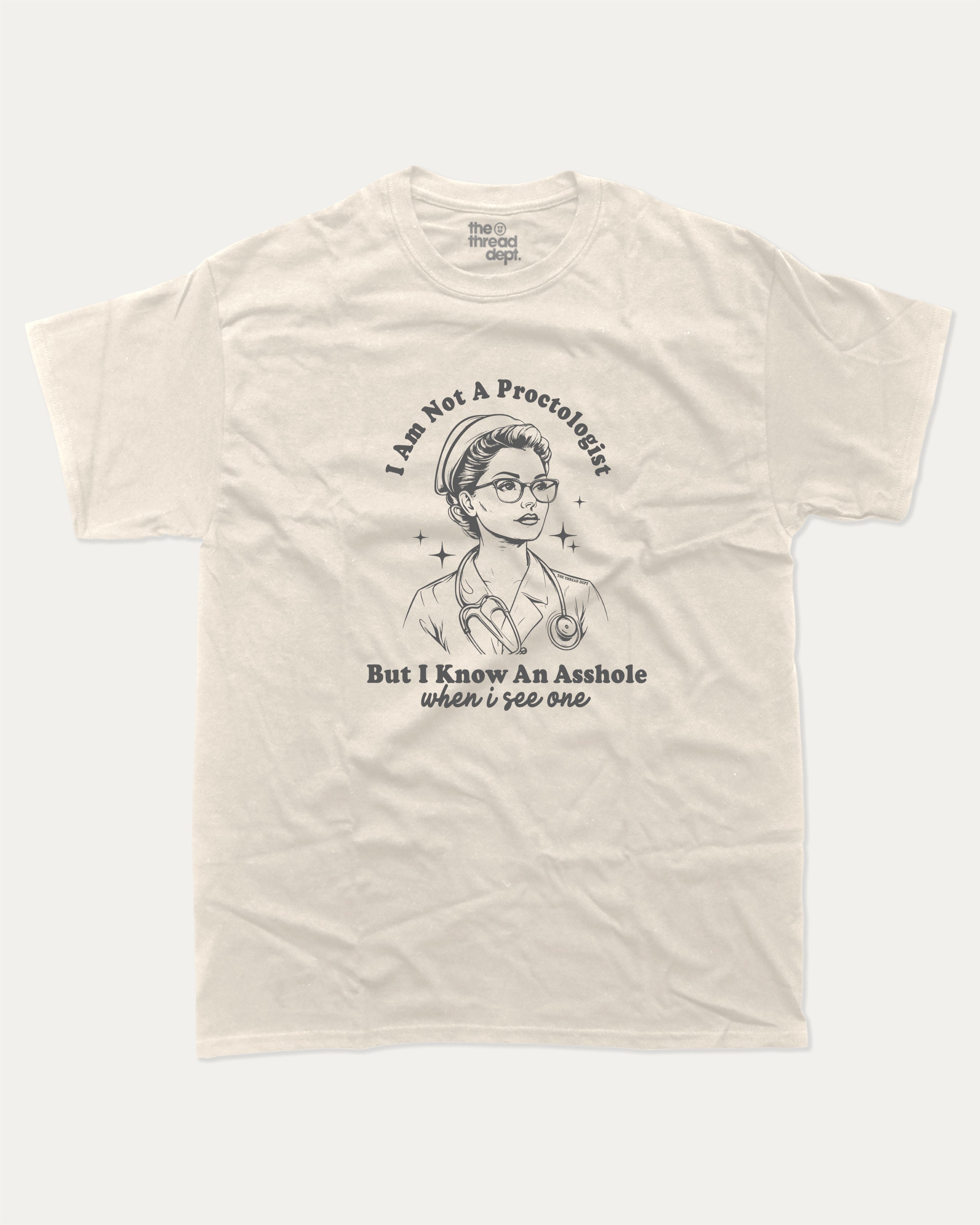 Beige t-shirt with I am not a Proctologist but I know asshole when I see one graphic and text on a white background