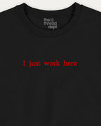 Black t-shirt with red text 'I just work here' and 'the thread dept.' logo on a white background