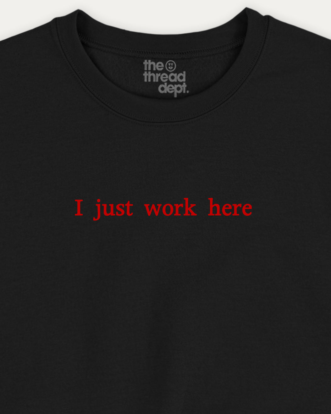 Black t-shirt with red text 'I just work here' and 'the thread dept.' logo on a white background