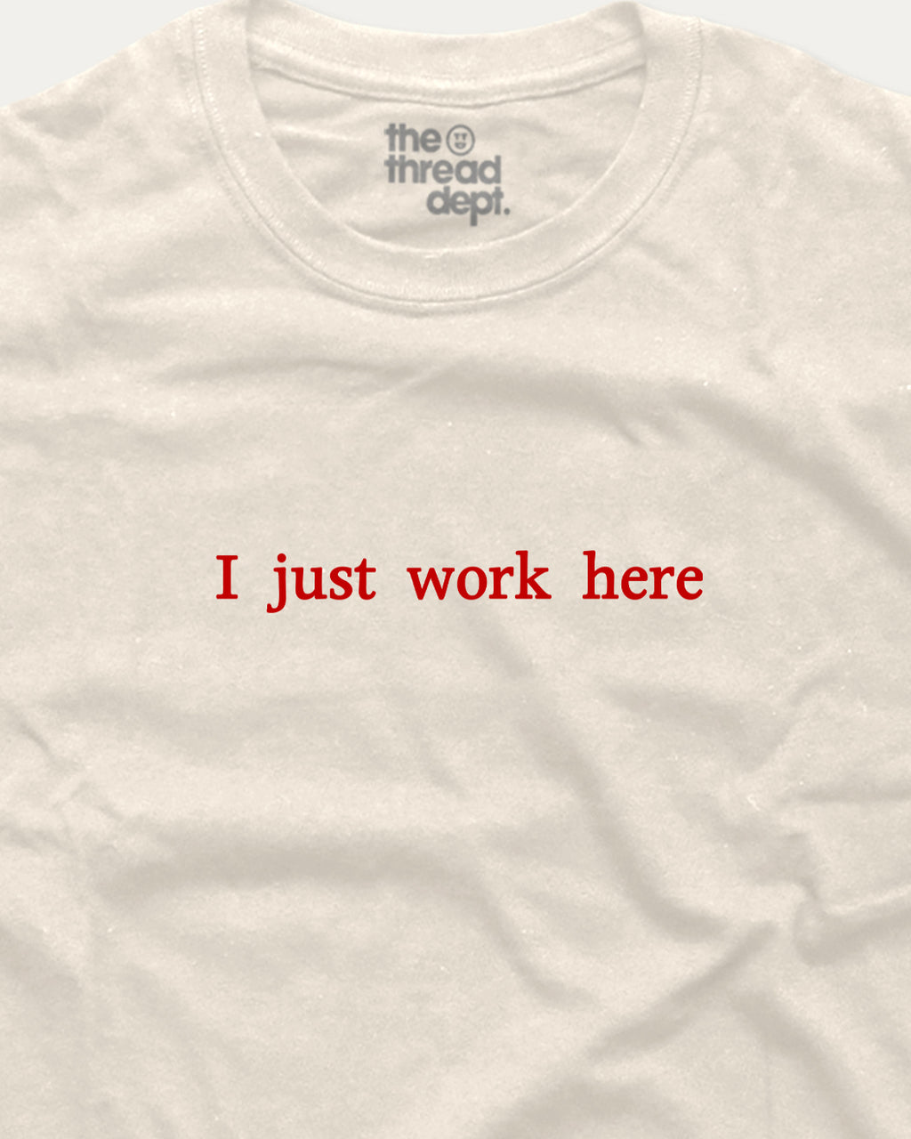 White t-shirt with red text 'I just work here' and 'the thread dept.' logo on a white background