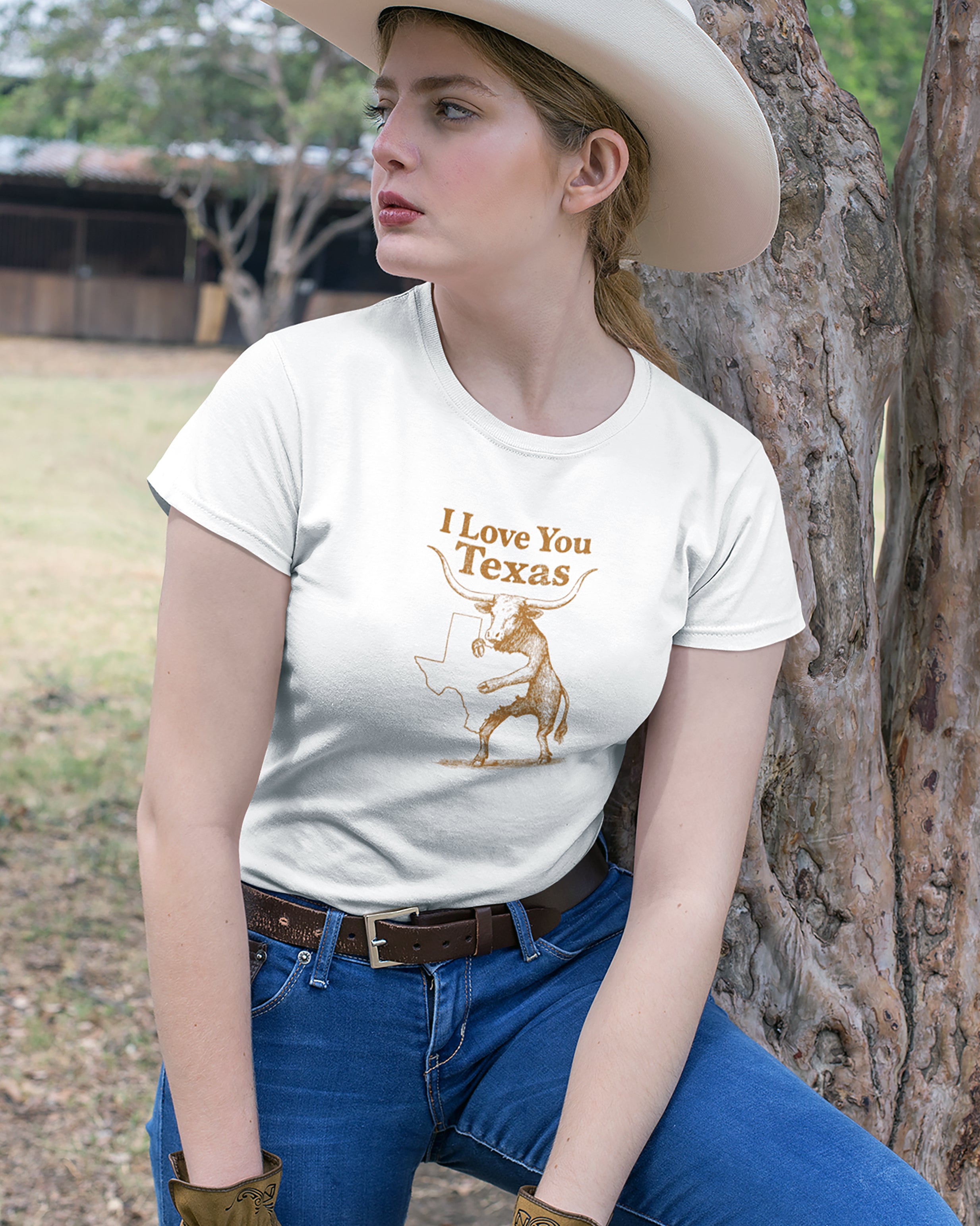Person wearing a white t-shirt with 'I Love You Texas' graphic outdoors.