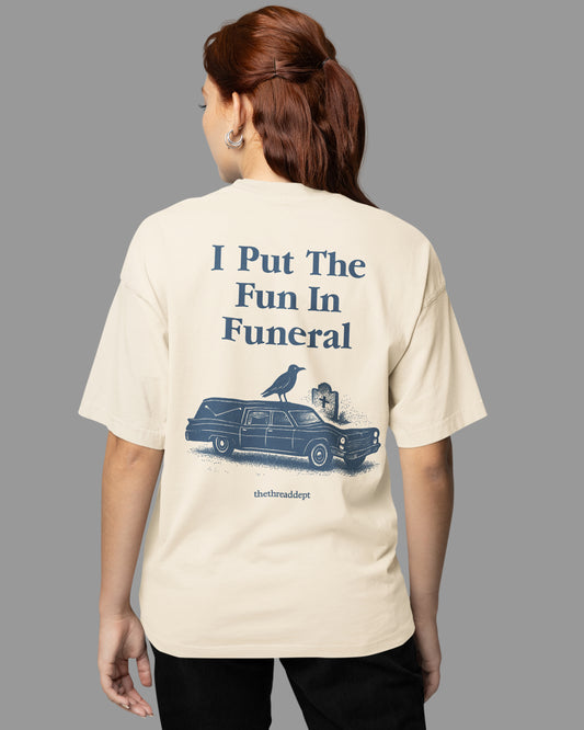 Person wearing a t-shirt with a i pute the fun in funeral graphic and text on the back, on a plain background