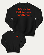 It's ok to fall in love with me graphic sweatshirt with bold and humorous print, Valentine Day Graphic T shirt, Perfect Gift for Valentine's Day, warm and cozy graphic for everyday wear. Perfect for adults and gift-giving. Black pullover.