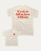 It's ok to fall in love with me graphic tee with bold and humorous print, Valentine Day Graphic T shirt, Perfect Gift for Valentine's Day, funny and trendy graphic. Perfect for adults and gift-giving. Cream shirt.