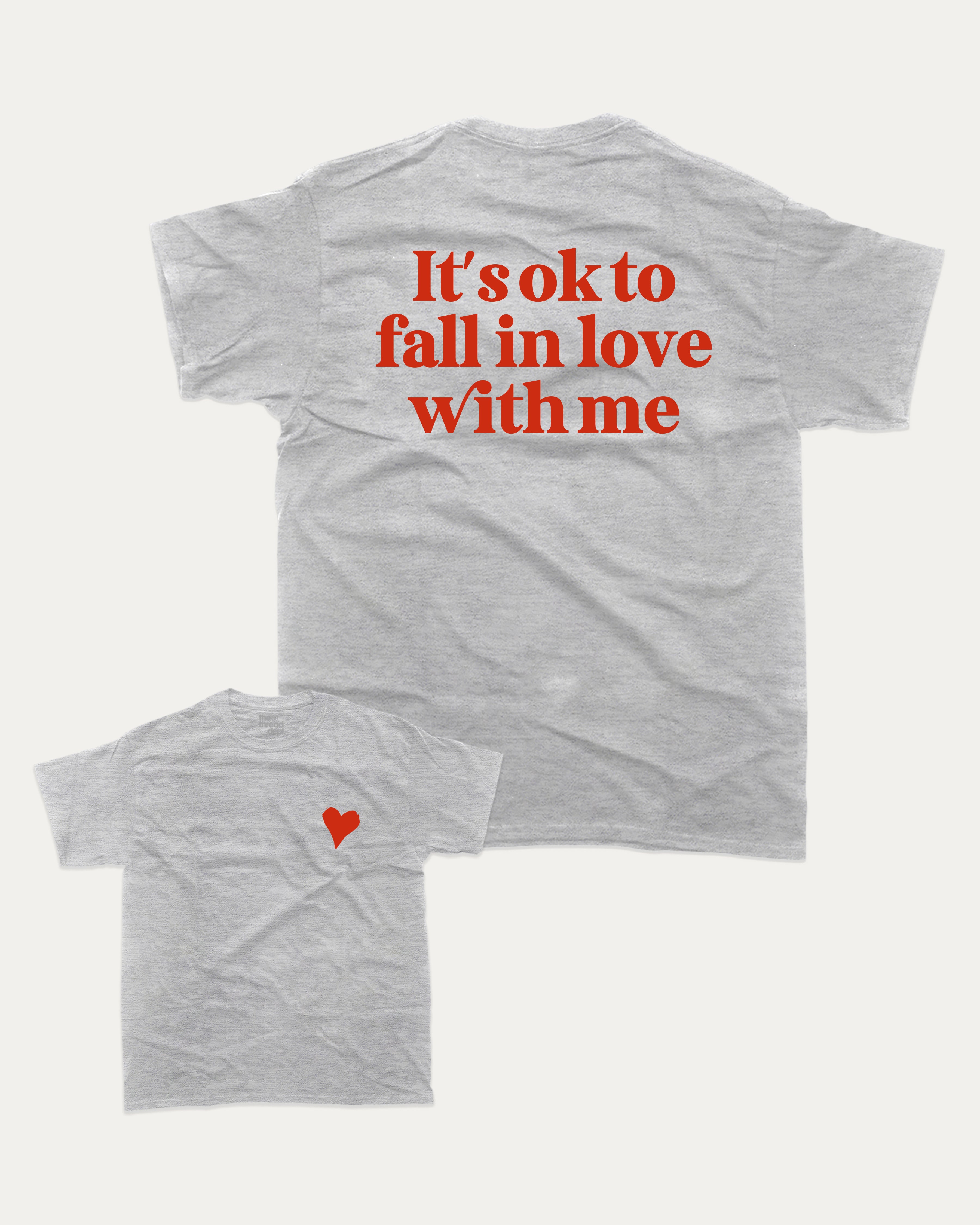 It's ok to fall in love with me graphic tee with bold and humorous print, Valentine Day Graphic T shirt, Perfect Gift for Valentine's Day, funny and trendy graphic. Perfect for adults and gift-giving. Heather Grey shirt.