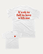 It's ok to fall in love with me graphic tee with bold and humorous print, Valentine Day Graphic T shirt, Perfect Gift for Valentine's Day, funny and trendy graphic. Perfect for adults and gift-giving. White shirt.