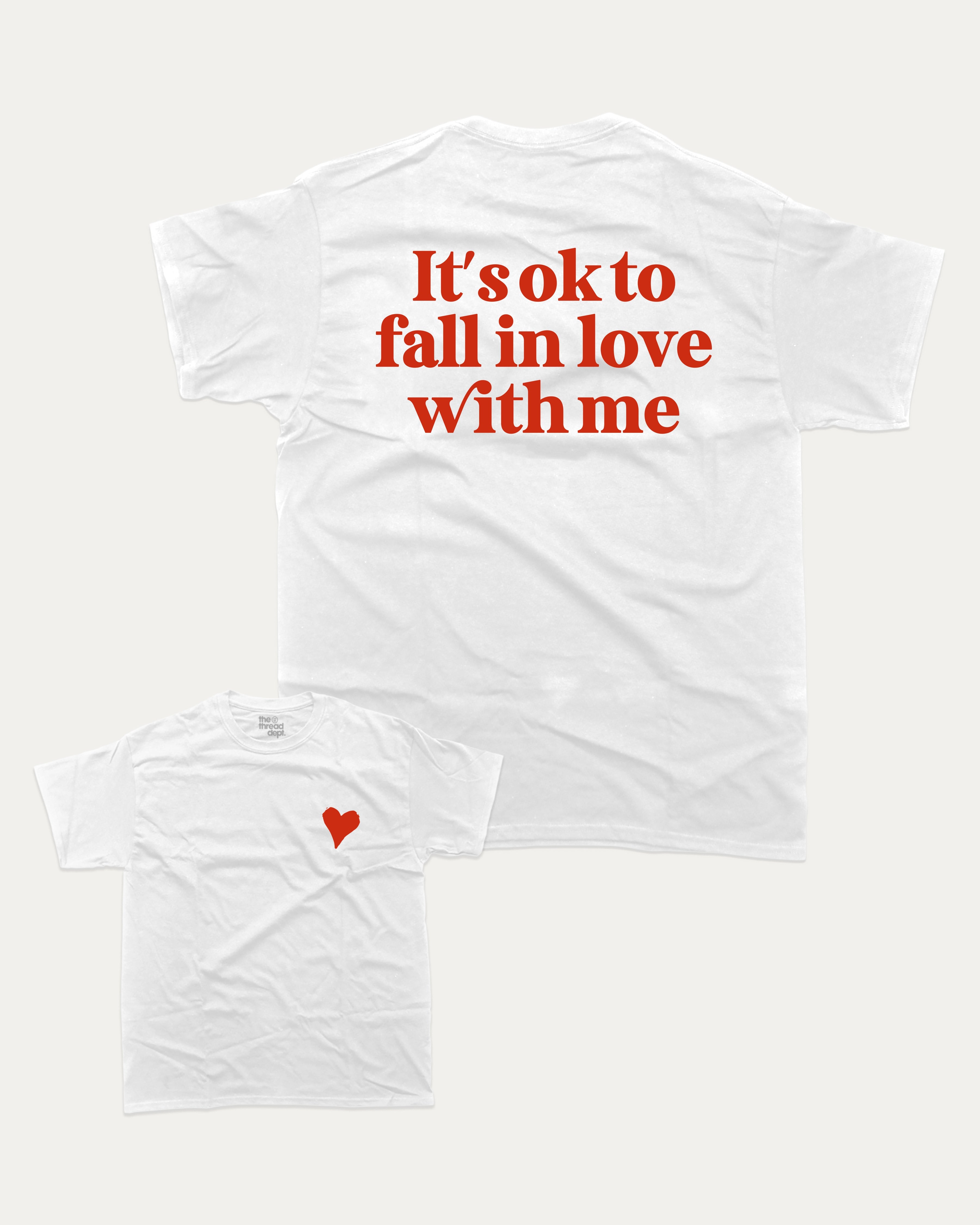 It's ok to fall in love with me graphic tee with bold and humorous print, Valentine Day Graphic T shirt, Perfect Gift for Valentine's Day, funny and trendy graphic. Perfect for adults and gift-giving. White shirt.