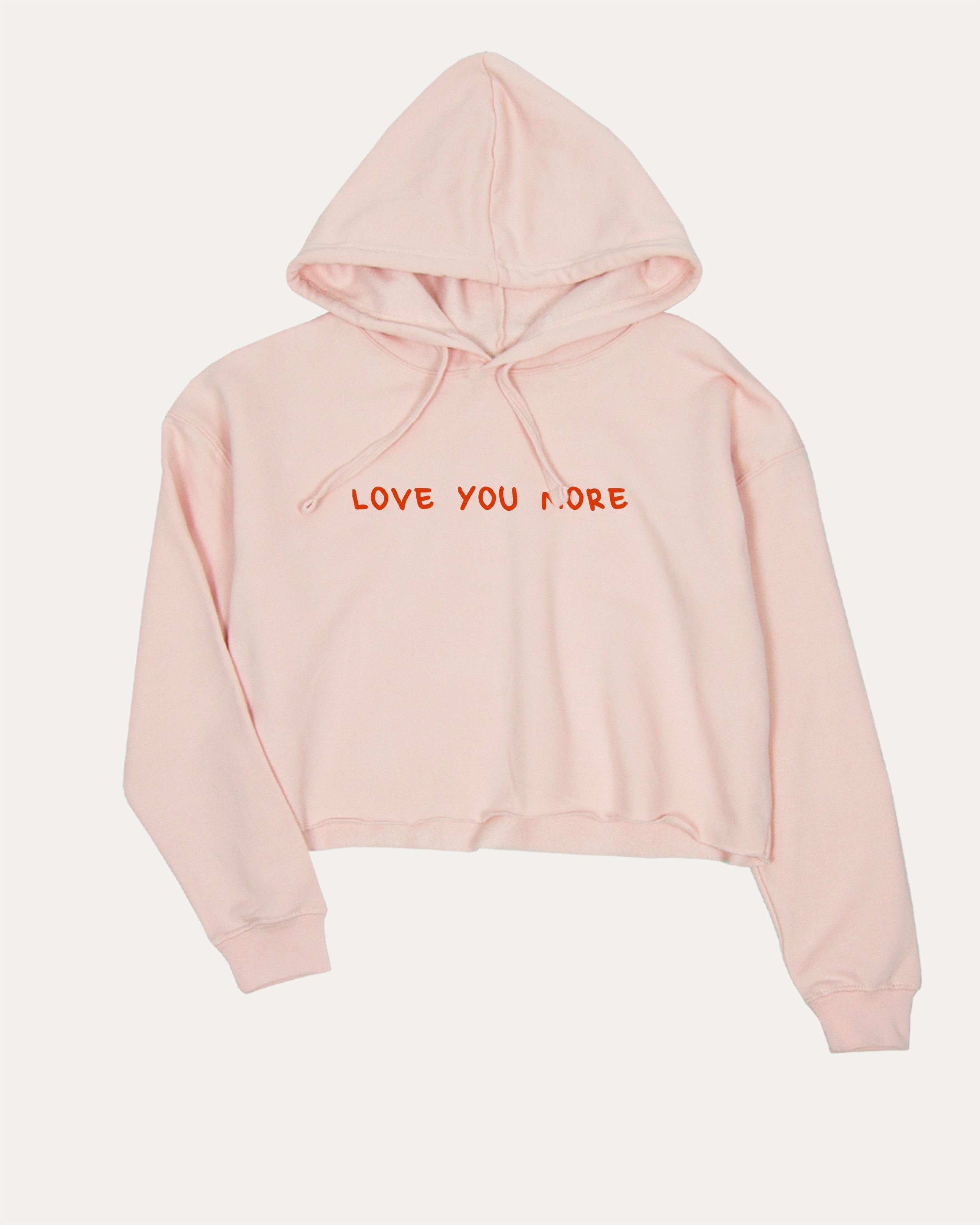 Love You More graphic crop hoodie with bold slogan print, stylish and playful design for women. Ideal for gifting and casual looks. Pink crop top..