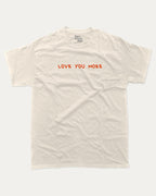 Love You More graphic tee with funny valentine print, trendy love graphic. Perfect for Valentine's Day gift-giving. Cream shirt.
