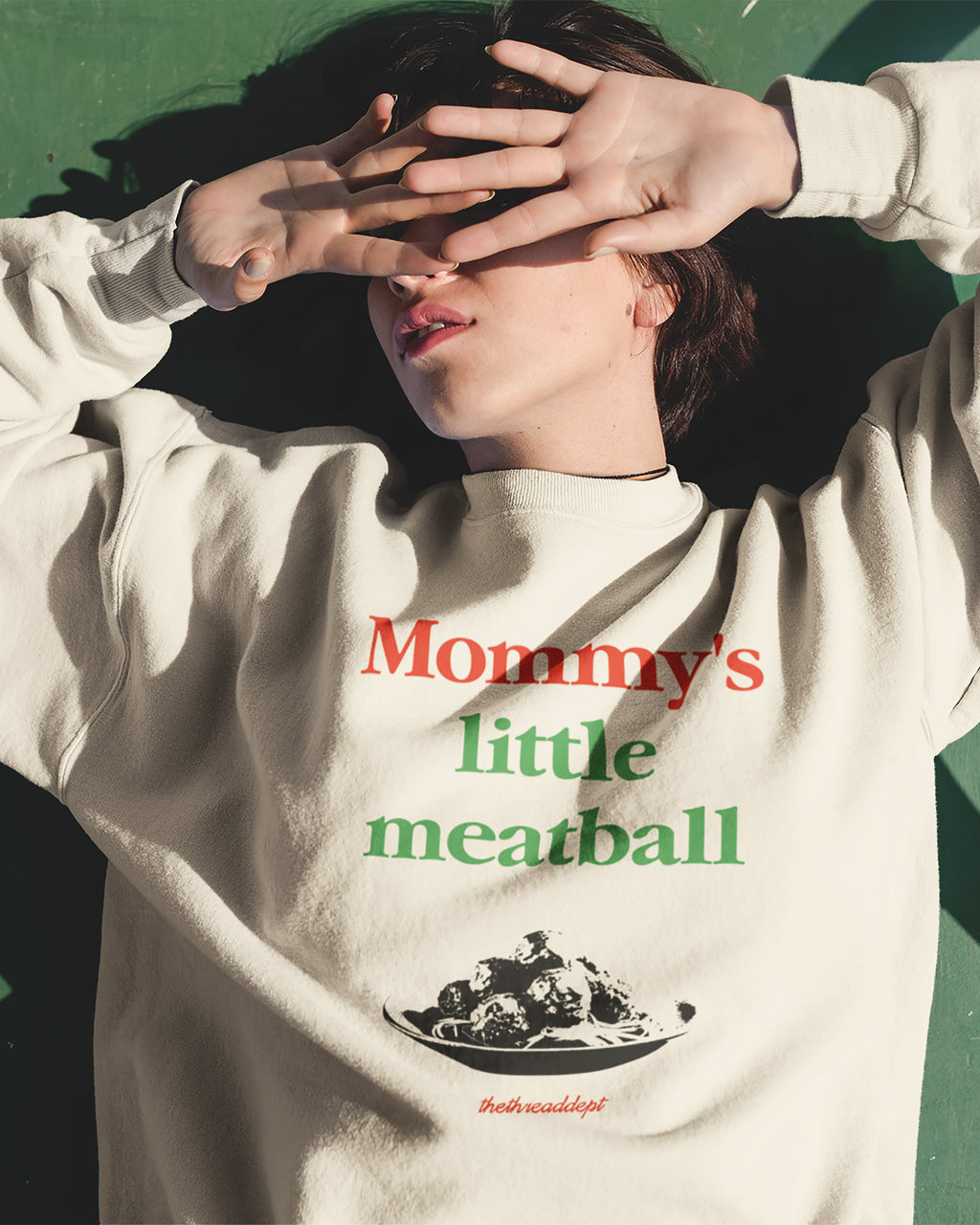 Person wearing a sweatshirt with 'Mommy's little meatball' text and graphic.